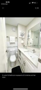 a bathroom with a toilet and a sink and a mirror at Bayfront in Portmore