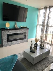 a living room with a fireplace and a tv at Bayfront in Portmore