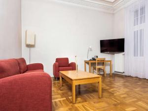 a living room with a couch and a table and a tv at Hotel Valdemars Riga managed by Accor in Rīga