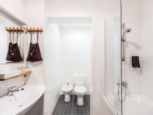 a bathroom with a toilet and a sink and a shower at Hotel Valdemars Riga managed by Accor in Rīga