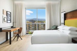 山景城Hyatt Centric Mountain View的一间有两张床、一张桌子和一扇窗户的酒店房间