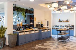 a kitchen with blue cabinets and a counter top at Hampton by Hilton Tours Centre, France in Tours