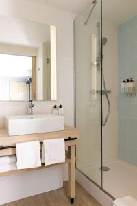 La salle de bains est pourvue d'un lavabo et d'une douche. dans l'établissement Hampton by Hilton Tours Centre, France, à Tours