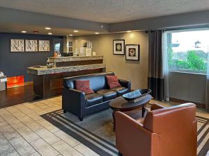 a living room with a couch and chairs and a bar at Quality Inn in Clinton