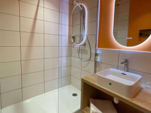 uma casa de banho com um lavatório e um chuveiro em greet hotel Castets Coeur des Landes em Castets