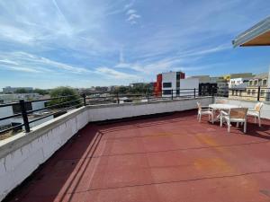 a patio with tables and chairs on a roof at Rooftop vue sur le stade de France in Saint-Denis