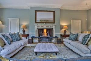 un soggiorno con 2 divani e un camino di Abbey House by Group Retreats a Saffron Walden