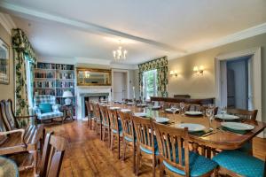 uma sala de jantar com uma mesa longa e cadeiras em Abbey House by Group Retreats em Saffron Walden