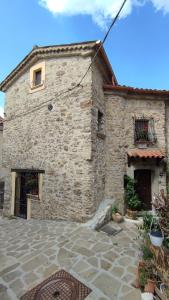 a large stone building with a patio in front of it at La torre della manca suite in Sasso di Castalda