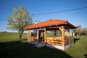 un gazebo con tetto rosso in un campo di Aronija Zlatar a Nova Varoš