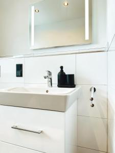 La salle de bains blanche est pourvue d'un lavabo et d'un miroir. dans l'établissement MELLoWY: Rückzugsort Cölpin 4 Personen, 