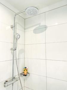 La salle de bains est pourvue d'une douche et de carrelage blanc. dans l'établissement MELLoWY: Rückzugsort Cölpin 4 Personen, 