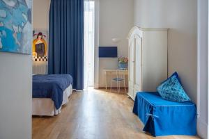 ナポリにあるB&B Donna Adelinaの小さなベッドルーム(ベッド1台、青い椅子付)