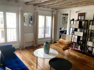 sala de estar con sofá azul y mesa en Charming 3F apartment in Paris' heart (61 sqm) en París
