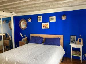1 dormitorio azul con 1 cama con paredes azules en Charming 3F apartment in Paris' heart (61 sqm) en París