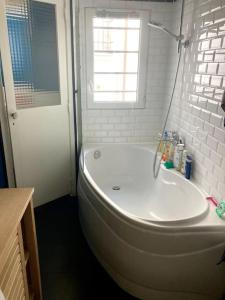 baño con bañera blanca y ventana en Charming 3F apartment in Paris' heart (61 sqm) en París