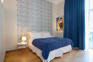 ナポリにあるB&B Donna Adelinaのベッドルーム(ベッド1台、青いカーテン付)