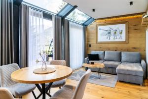 un soggiorno con divano e tavolo di Apartament Magiczne Podhale by Apart Concept Podhale a Kościelisko