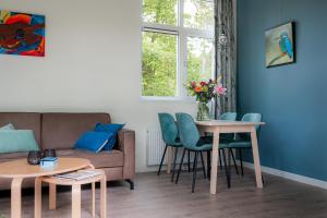 een woonkamer met een bank en een tafel bij Lodge IJsvogel Nunspeet Veluwe in Nunspeet