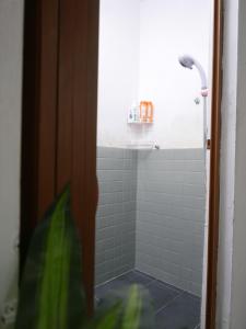 y baño con ducha de azulejos blancos. en little heritage home, en George Town