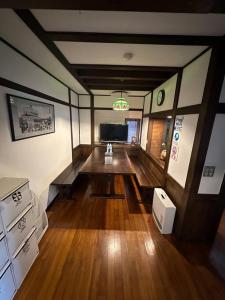 a living room with a wooden table and a television at アンドステイ中野弥生町 in Tokyo