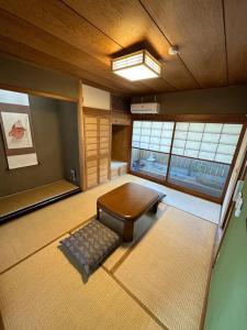 a room with a table and a bench and windows at アンドステイ中野弥生町 in Tokyo