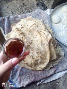 a person holding a glass of sauce next to a tortilla at Marmr in Abū Turābah
