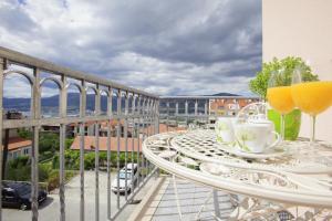 a balcony with a table and two glasses of orange juice at Amigo Comfort Apartments in Split