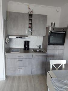een keuken met roestvrijstalen kasten en een wastafel bij Apartment Marina Wendtorf in Wendtorf