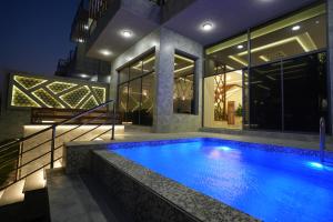 a swimming pool in front of a house at night at منتجع اجمكان Ajmkan Resort in Al Khobar