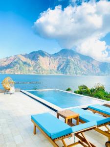 a swimming pool with a view of the water and mountains at D Khaylas in Kintamani