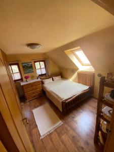 Schlafzimmer im Dachgeschoss mit einem Bett und einem Fenster in der Unterkunft Bauer Vendégház Püspökszentlászló in Hosszúhétény-Szőlőhegy