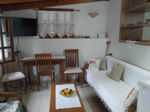 a living room with a white couch and a table at Panthea Cottage in Stavroupoli +51 photos