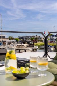 泽沃德Cosy tiny houseboats near beach and restaurants by Weltevreden Experience的一张桌子,上面放着两杯和一碗柠檬