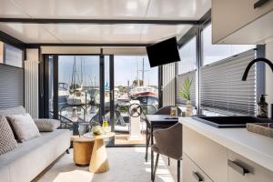 泽沃德Cosy tiny houseboats near beach and restaurants by Weltevreden Experience的厨房以及享有码头景致的客厅。