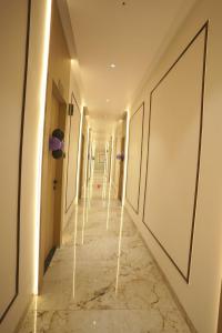 Hotel World View في Utrān: ممر به جدران بيضاء وأرضية من الرخام وممر طويل