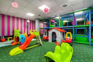a childrens play room with a slide and a playground at Prawdzic Family Resort & Wellness in Gdańsk