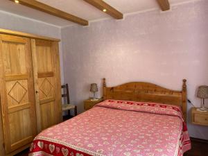 a bedroom with a bed with a red bedspread at Agriturismo Meizoun Blancho in Fenestrelle