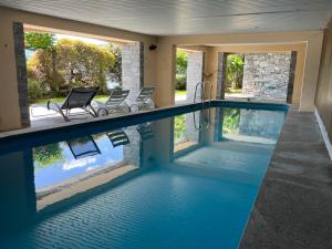 ein Pool in einem Haus mit Stühlen in der Unterkunft Villa Aurora: Porto Ronco in Ronco sopra Ascona