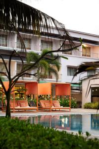 a hotel with orange chairs next to a swimming pool at Hotel Sonar Bangla Mandarmoni in Mandarmoni