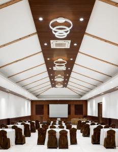 a conference room with tables and chairs and a screen at Hotel Sonar Bangla Mandarmoni in Mandarmoni