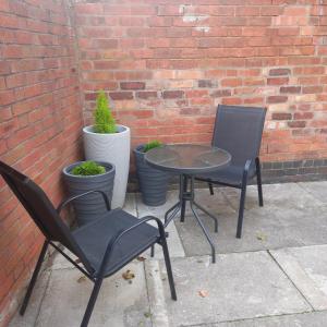 two chairs and a table in front of a brick wall at Eighty Four in Birmingham