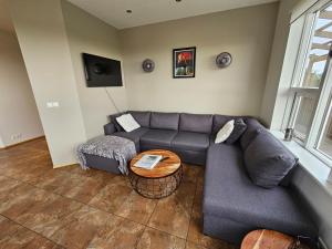 a living room with a couch and a table at Skeiðvellir Villa in Hella