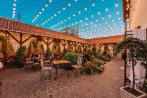 a patio with tables and chairs in a building with lights at Pensiunea Venetia Sighisoara in Sighişoara