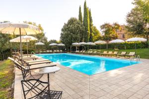 uma piscina com espreguiçadeiras e guarda-sóis em Appartamento Sangiovese em Montepulciano