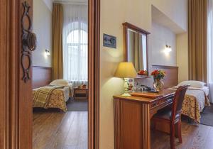 a hotel room with a bedroom with a desk and a mirror at Ligotel in Saint Petersburg