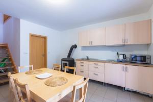 a kitchen and dining room with a wooden table and chairs at Hájenka Kozlov in Litomyšl