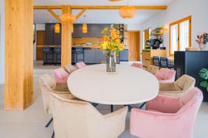 comedor con mesa blanca y sillas rosas en Casa Lua Galera, en Galera