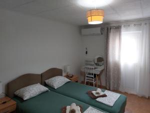 sypialnia z 2 łóżkami, stołem i oknem w obiekcie Vicky Apartments w Kotorze