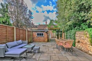 eine Terrasse mit einem Sofa, Stühlen und einem Tisch in der Unterkunft Finest Retreats - The Old Coach House in Stony Stratford